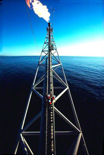 three-workers-venture-out-on-to-an-off-shore-rigs-torch_DM