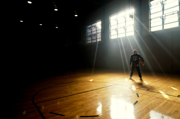 man standing with basketball in gym