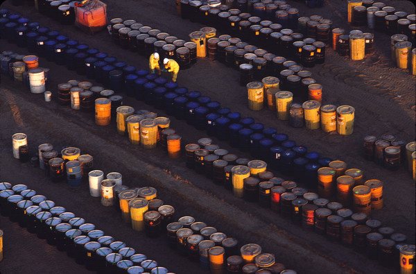 aerial of men counting barrels at a toxic waste facility-horizontal