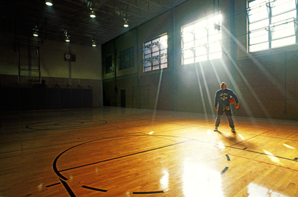 man standing with basketball in gym