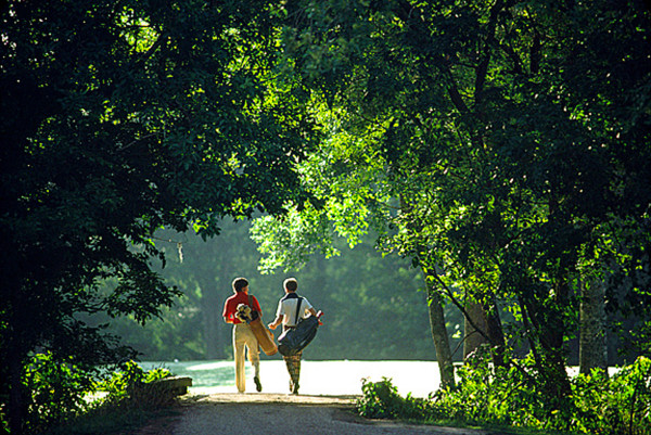 two men walking with golf clubs