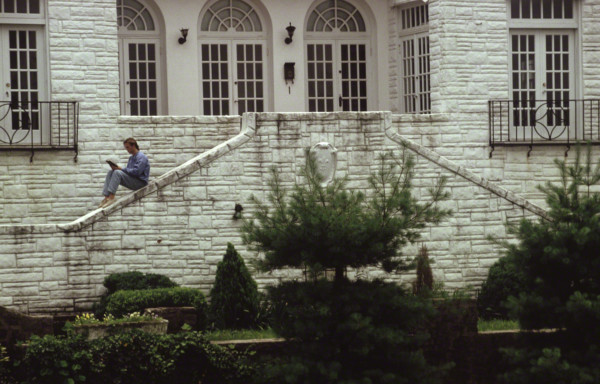 student reading in front of limestone building
