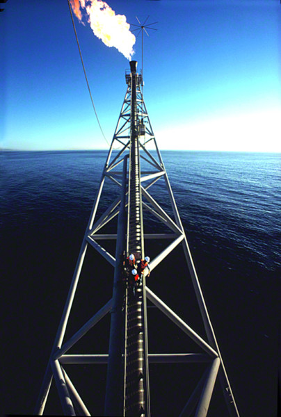 three workers venture out on to an off shore rig's torch