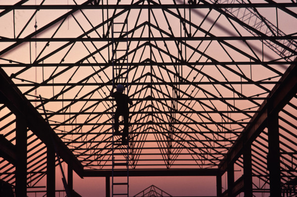 man climbing up ladder on building frame